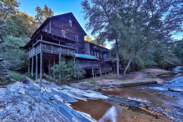 rear view of property featuring a deck with water view