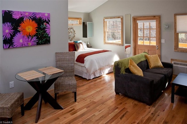 bedroom with light hardwood / wood-style floors and vaulted ceiling