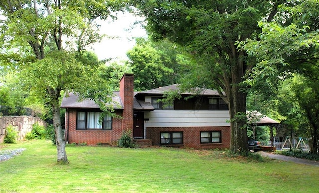 split level home featuring a gazebo, a chimney, a front lawn, and brick siding