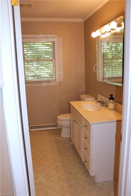 half bathroom featuring toilet, plenty of natural light, baseboard heating, and crown molding