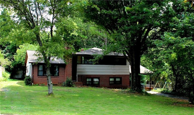 tri-level home featuring a front yard and brick siding