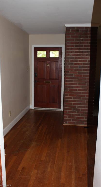 foyer featuring baseboards and dark wood finished floors