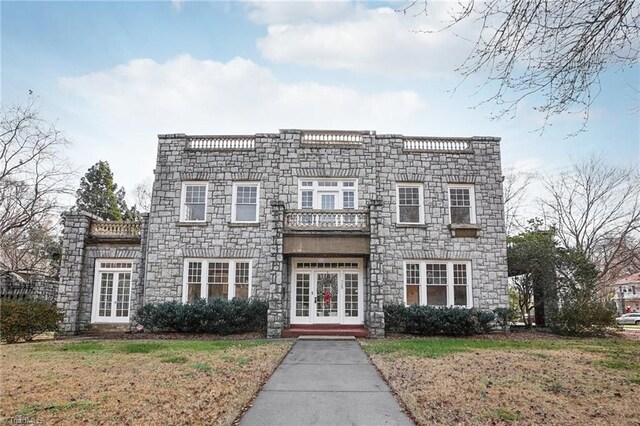 view of front of house with a front yard and a balcony