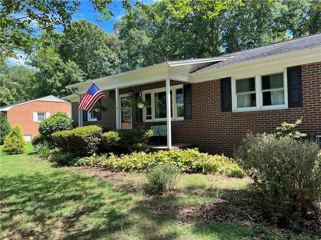 view of front of home with brick siding and a front lawn