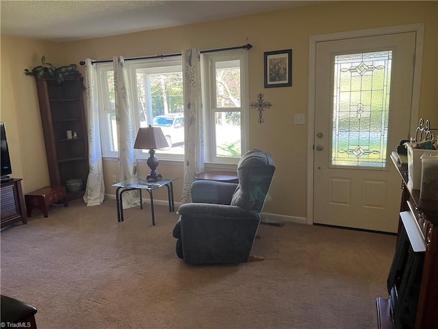 living area featuring baseboards, visible vents, and carpet floors