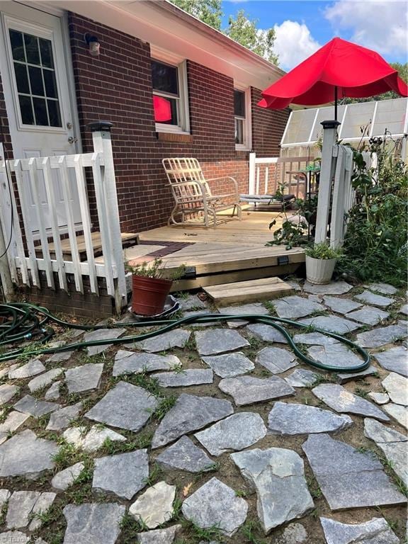 view of patio featuring a wooden deck and fence