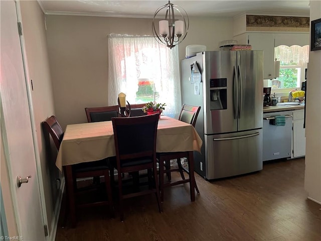 dining area with sink, a chandelier, dark hardwood / wood-style flooring, and crown molding