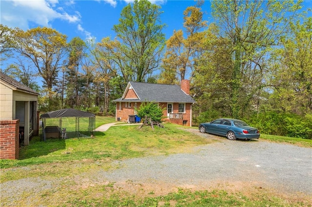 4478 Ogburn Ave, Winston-Salem, NC 27105 - view of front facade with brick siding, a front lawn, driveway, and a chimney