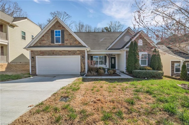 craftsman-style home with a garage, a front yard, concrete driveway, and stone siding