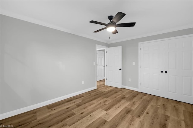 unfurnished bedroom featuring ornamental molding, light wood-type flooring, ceiling fan, and a closet