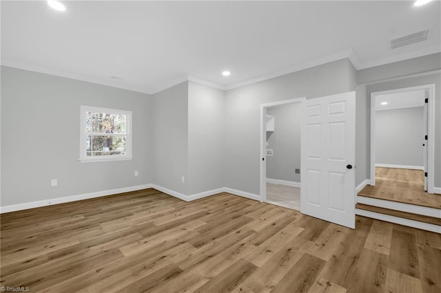 interior space featuring ornamental molding and light hardwood / wood-style floors