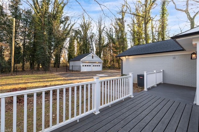 deck featuring a garage, an outdoor structure, and a yard