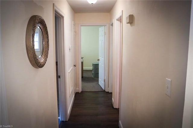 hallway with baseboards and dark wood-style flooring