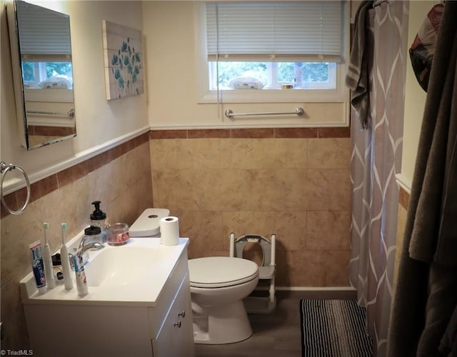 full bathroom featuring tile walls, toilet, wainscoting, a shower with curtain, and vanity