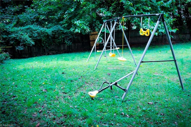 view of playground with a yard and a fenced backyard