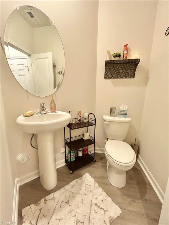 bathroom featuring hardwood / wood-style floors and toilet