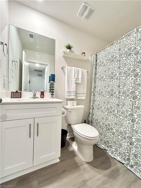 bathroom featuring hardwood / wood-style flooring, vanity, and toilet