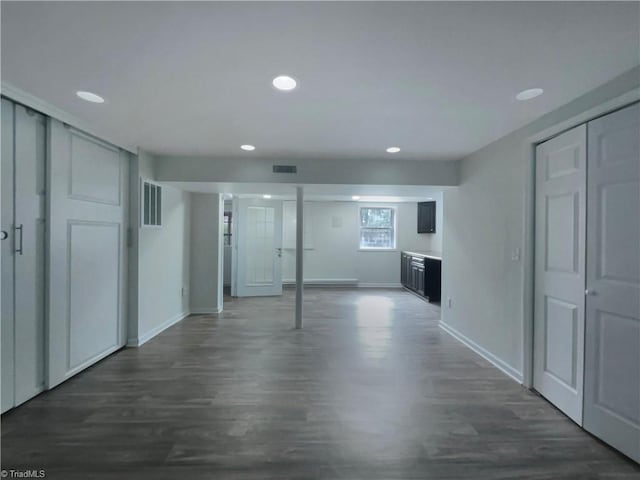 corridor with baseboards, visible vents, dark wood finished floors, and recessed lighting