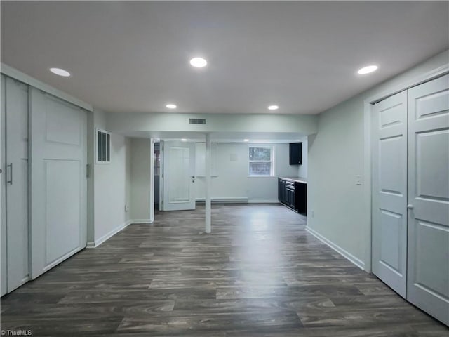 basement featuring recessed lighting, dark wood-style flooring, and visible vents