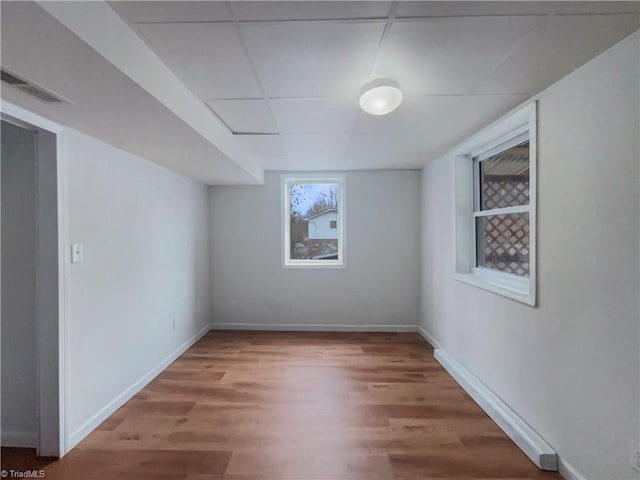 unfurnished room with wood finished floors, visible vents, and baseboards