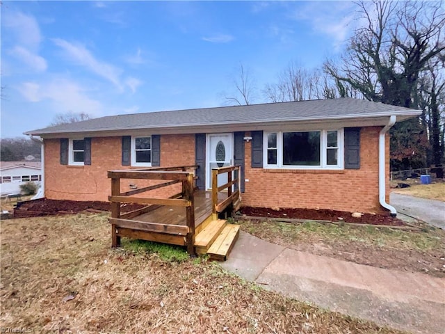 single story home featuring brick siding and roof with shingles