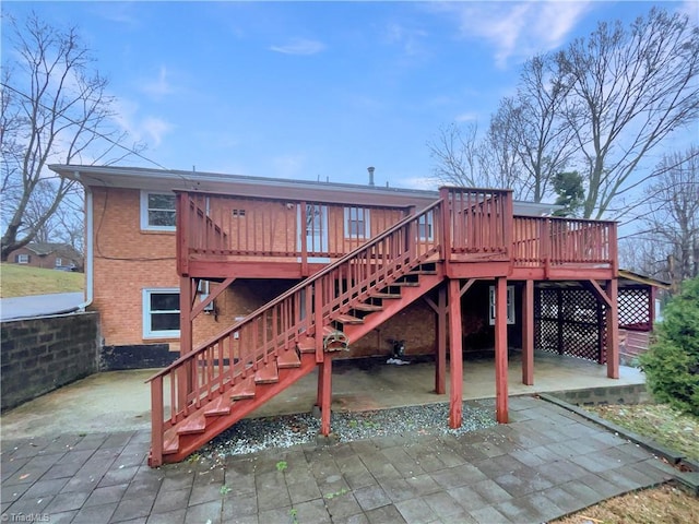 back of house with brick siding, stairway, a patio area, and a wooden deck