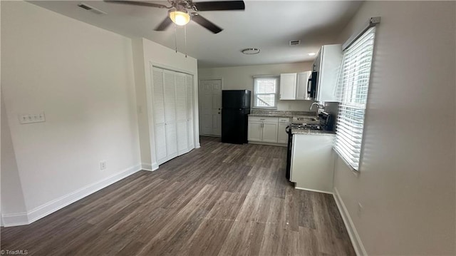 1004 Tabor St, High Point, NC 27262 - kitchen with freestanding refrigerator, ceiling fan, white cabinets, dark wood-style flooring, and stainless steel range oven