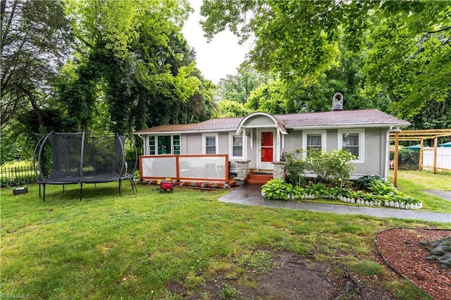 1415 Wiltshire St, High Point, NC 27265 - ranch-style home with a trampoline, a chimney, stucco siding, and a wooden deck