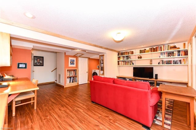 living room with hardwood / wood-style flooring, washer / clothes dryer, and a textured ceiling