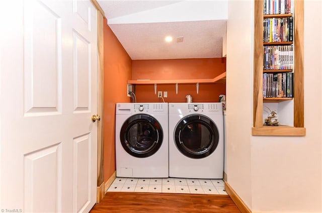 washroom with washer and clothes dryer and a textured ceiling