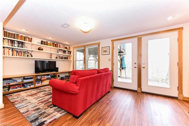 living room featuring wood-type flooring and a textured ceiling