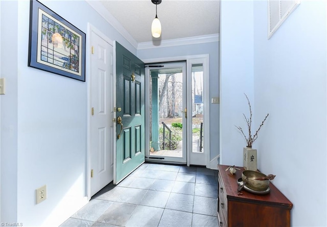 entrance foyer with crown molding and light tile patterned floors