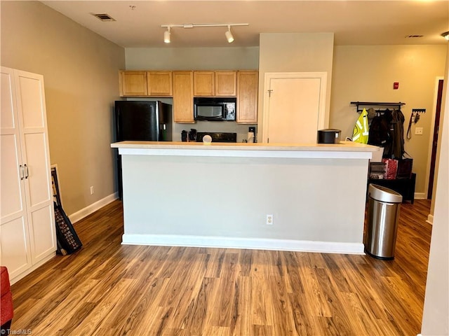 411 Washington St Unit 204, Greensboro, NC 27401 - kitchen featuring black appliances, light brown cabinetry, wood finished floors, and rail lighting