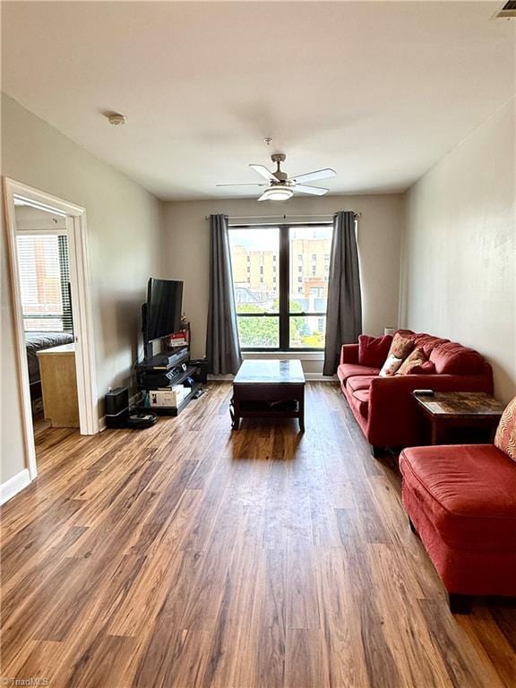 411 Washington St Unit 204, Greensboro, NC 27401 - living area featuring plenty of natural light, wood finished floors, a ceiling fan, and baseboards