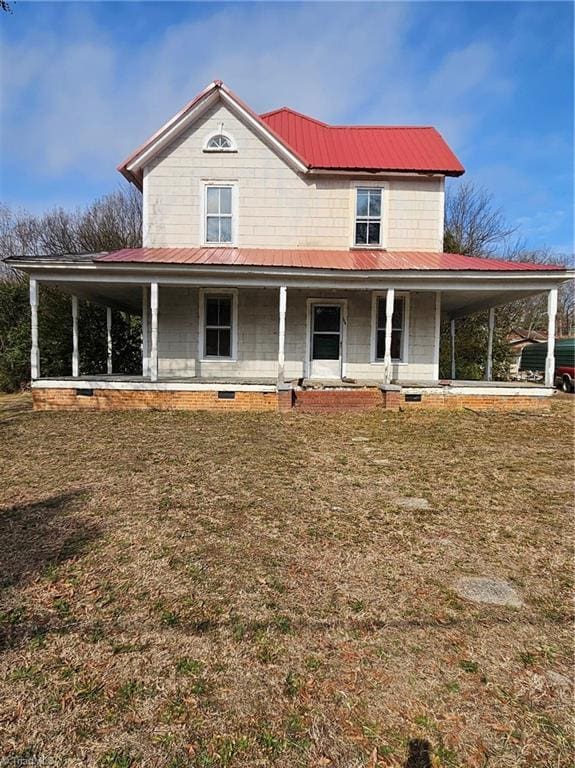 farmhouse with metal roof, a porch, and a front yard