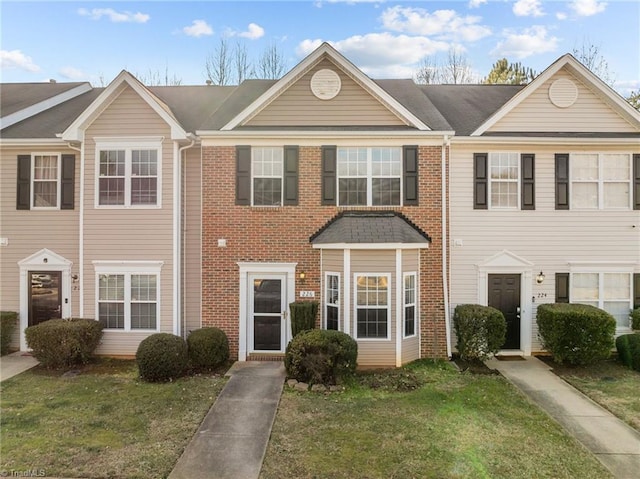 townhome / multi-family property featuring a front lawn