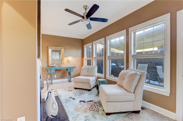 sitting room with ceiling fan, plenty of natural light, and light tile patterned floors