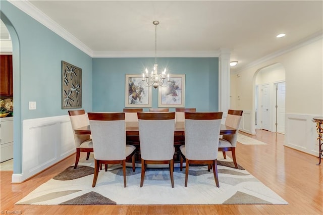 dining room with washer / clothes dryer, an inviting chandelier, light wood-type flooring, and crown molding