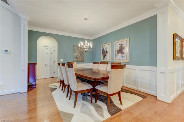 dining area featuring a chandelier, ornamental molding, and light hardwood / wood-style flooring