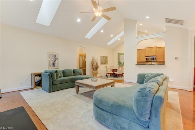 living room with ceiling fan, light hardwood / wood-style flooring, and high vaulted ceiling