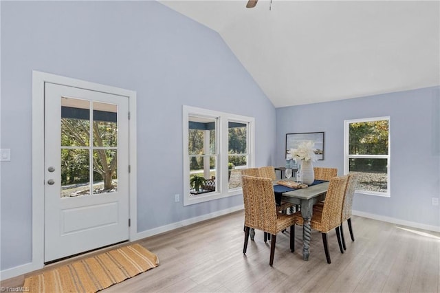 dining area with light hardwood / wood-style floors, high vaulted ceiling, and ceiling fan