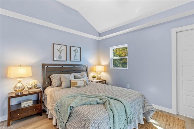 bedroom with hardwood / wood-style floors and vaulted ceiling