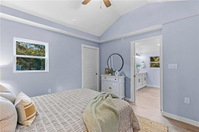 bedroom featuring vaulted ceiling, light hardwood / wood-style flooring, ensuite bathroom, and ceiling fan