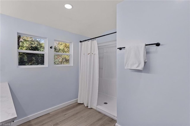 bathroom with curtained shower and hardwood / wood-style flooring