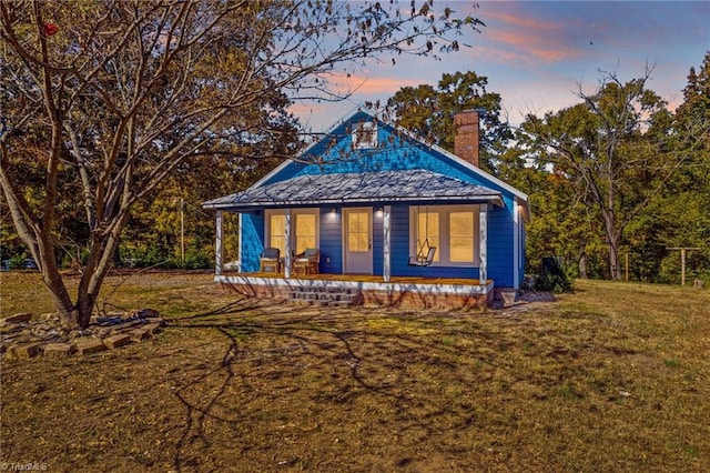 exterior space featuring a lawn and a porch