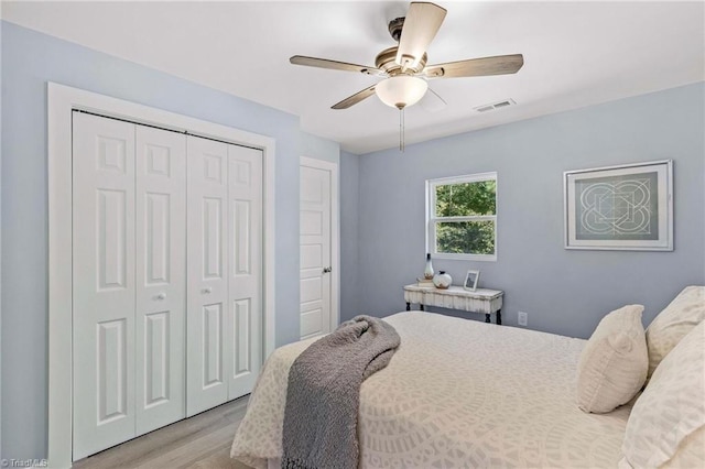 bedroom featuring a closet, light wood-type flooring, and ceiling fan