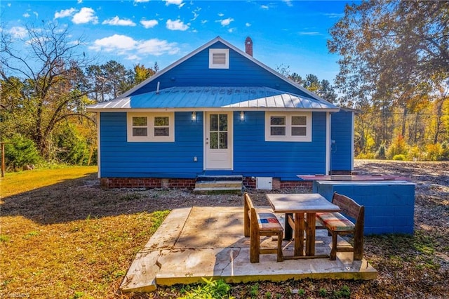 rear view of house featuring a patio and a lawn