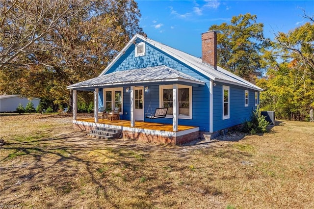 back of house with a yard, central AC unit, and a porch