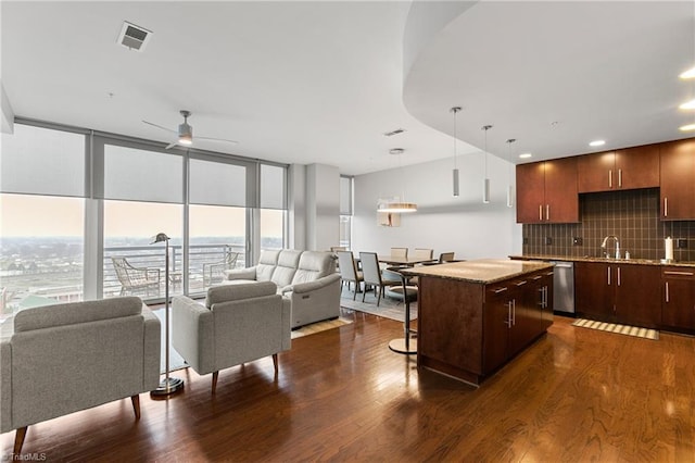 kitchen featuring dark wood-type flooring, backsplash, a center island, and a breakfast bar