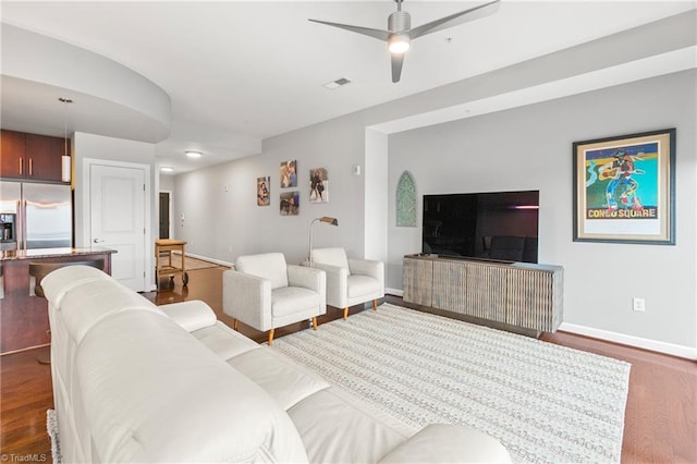 living room featuring dark wood-type flooring and ceiling fan